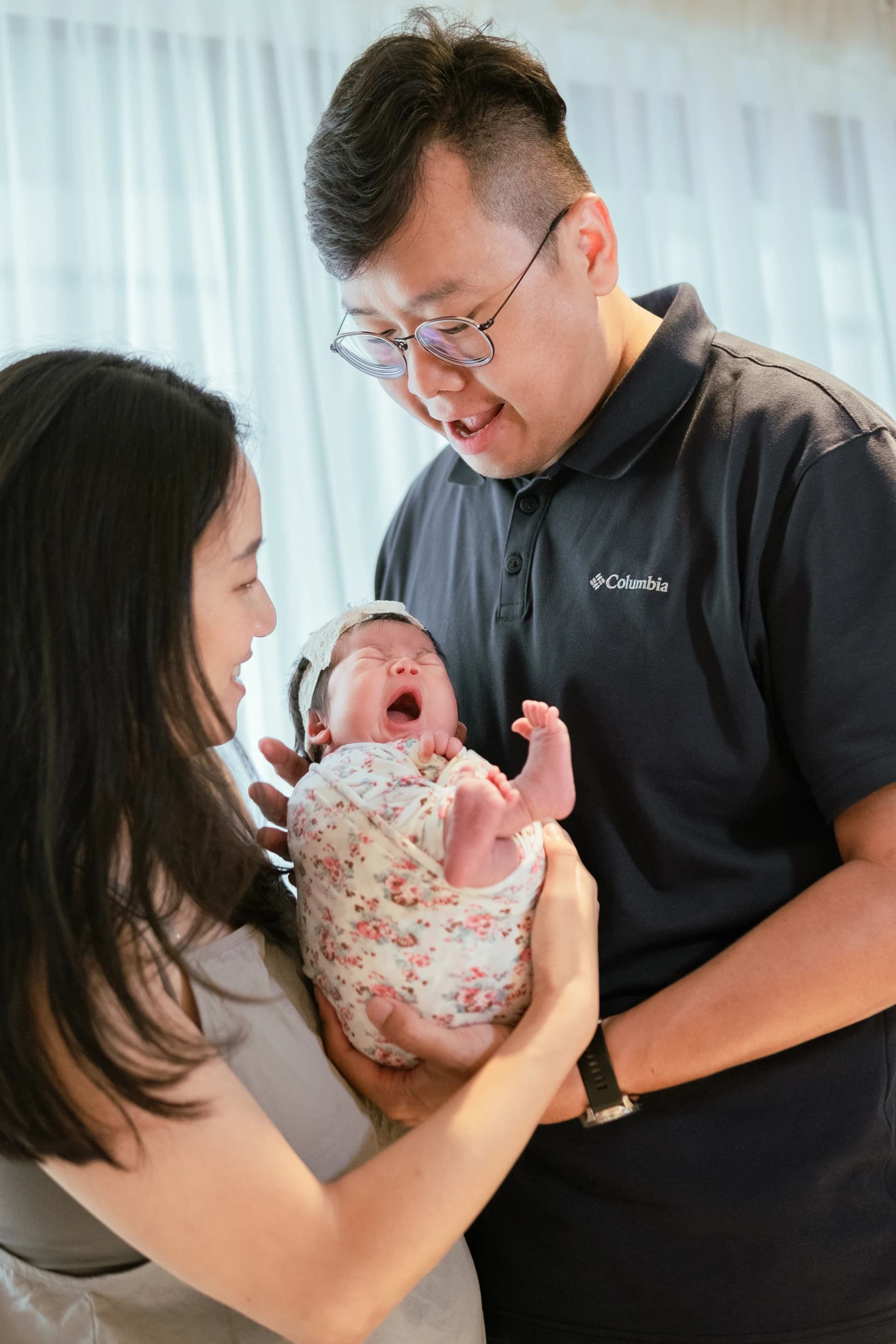Father holding newborn baby gently in Saigon by Kevin Duong