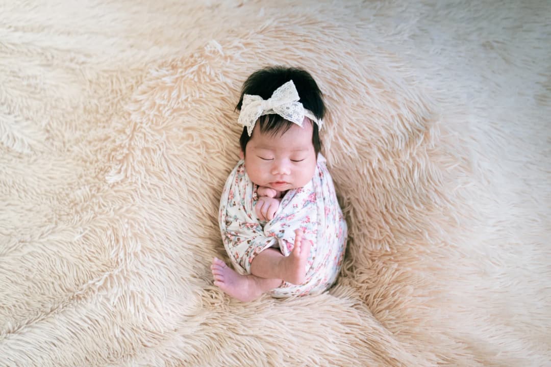 Sleeping newborn wrapped in a floral blanket